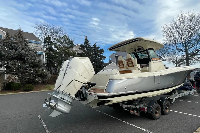 Slide: The Image of 2026 Chris-Craft 310 Catalina boat on trailer, parked outdoors under a cloudy sky. - 4