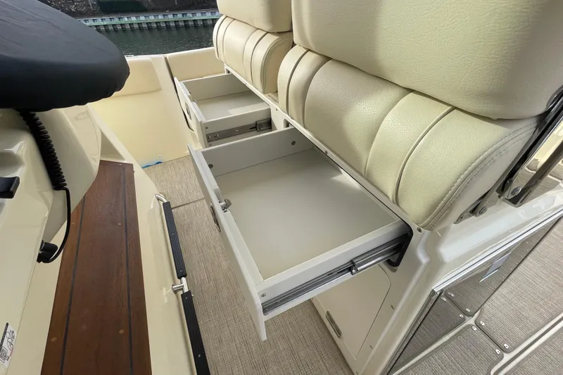Slide: The Image of 2026 Chris-Craft 310 Catalina boat interior with open storage drawers and cushioned seating. - 40