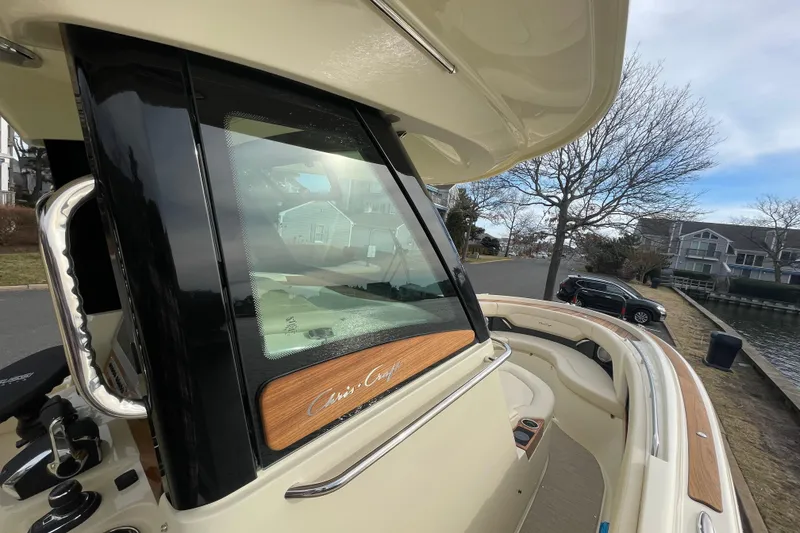 Slide: The Image of 2026 Chris-Craft 310 Catalina boat docked near waterfront homes, showcasing sleek design. - 52