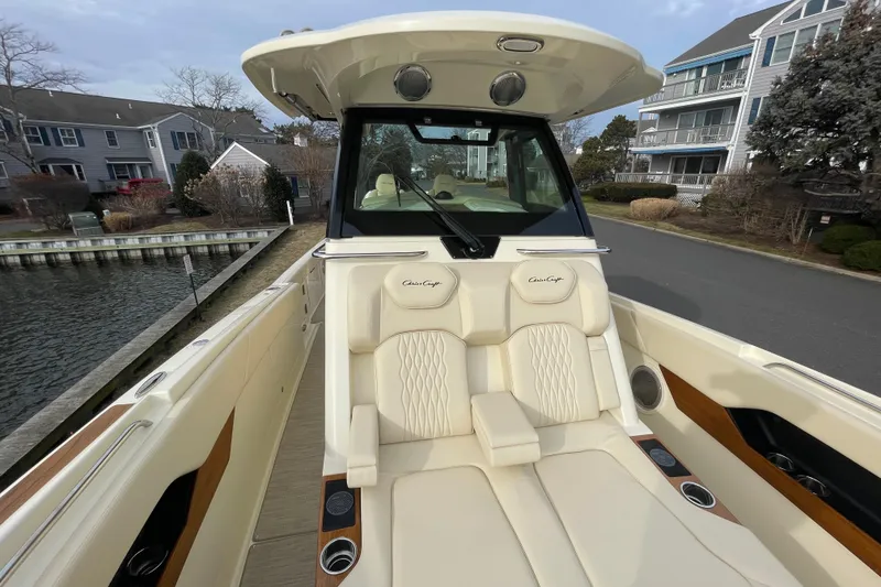 Slide: The Image of 2026 Chris-Craft 310 Catalina boat with luxurious seating, docked near waterfront homes. - 56
