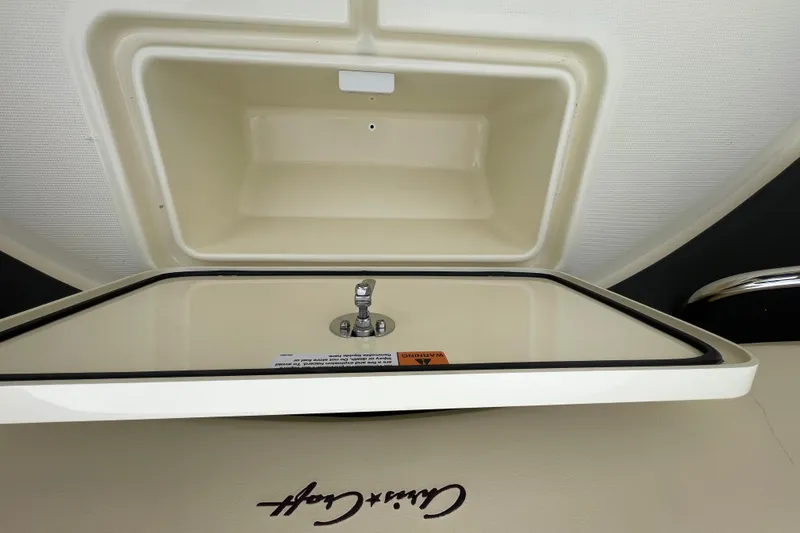 Slide: The Image of 2026 Chris-Craft 310 Catalina storage compartment with logo and latch detail. - 74