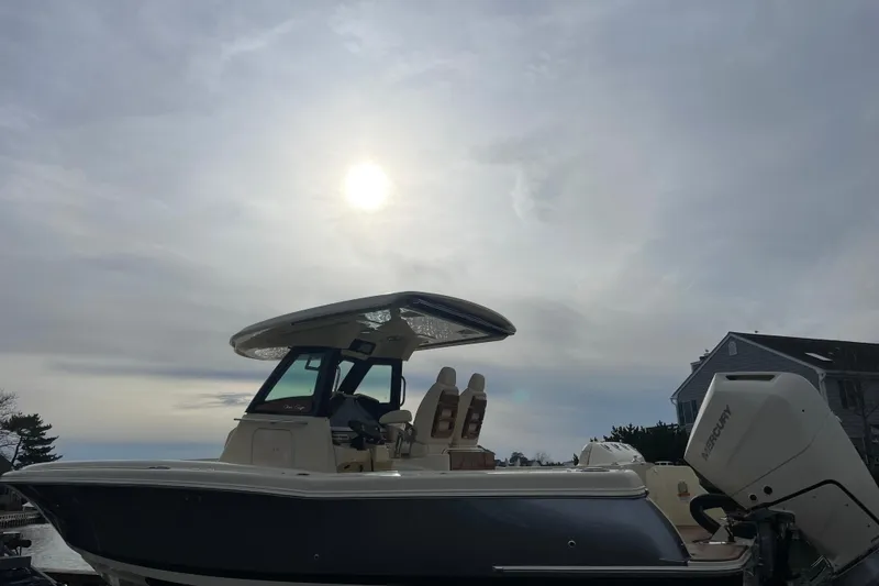 Slide: The Image of 2026 Chris-Craft 310 Catalina boat under cloudy sky with sun. - 82