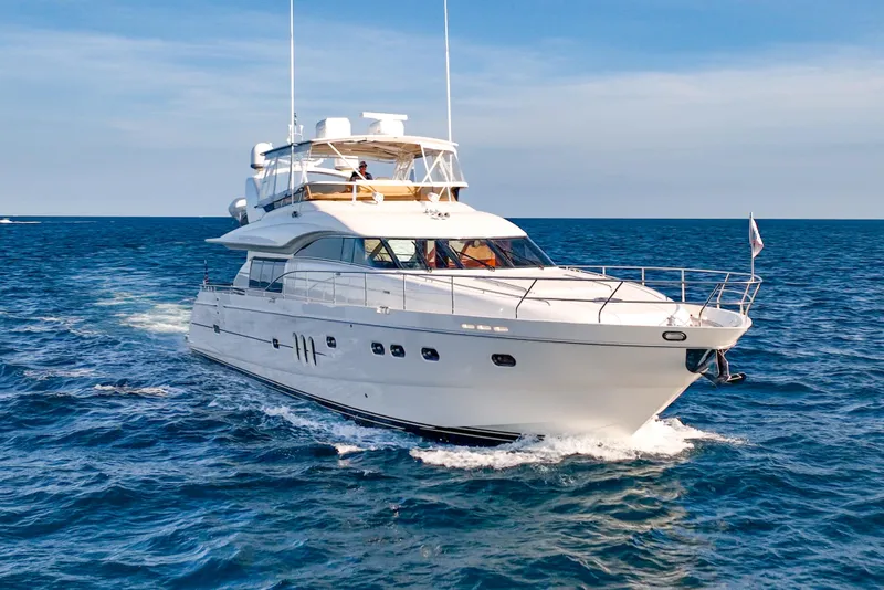 The Image of 2004 Viking Princess Flybridge yacht cruising on open sea under clear skies. - 0