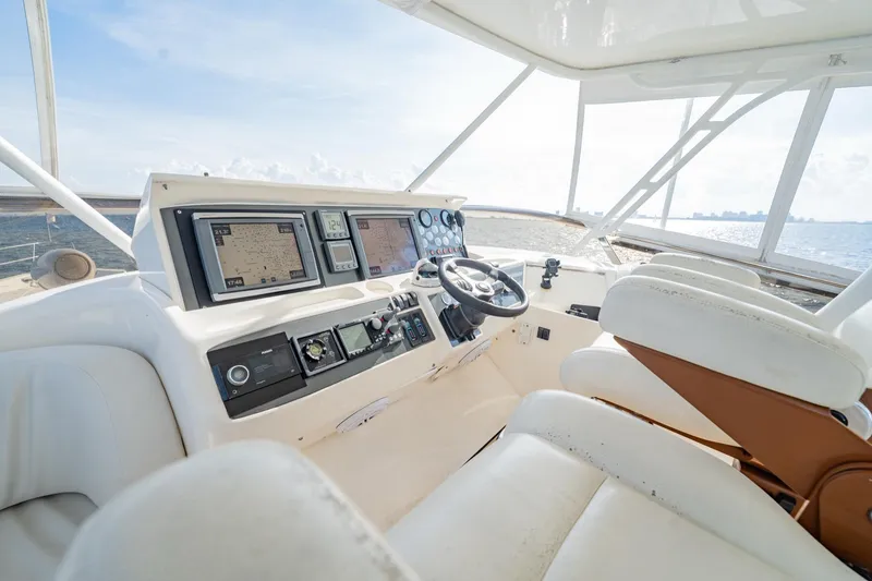 Slide: The Image of 2004 Viking Princess Flybridge yacht helm with navigation screens and steering wheel. - 15
