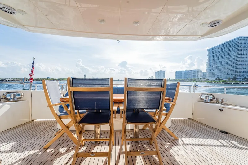 Slide: The Image of 2004 Viking Princess Flybridge yacht deck with chairs, overlooking ocean and cityscape. - 19