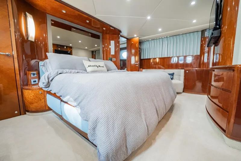 Slide: The Image of Luxurious 2004 Viking Princess Flybridge yacht bedroom with elegant wood finishes and plush bedding. - 30