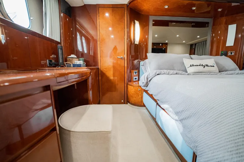 Slide: The Image of Luxurious 2004 Viking Princess Flybridge yacht bedroom with elegant wood finishes and cozy bedding. - 31
