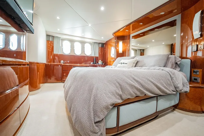 Slide: The Image of Luxurious 2004 Viking Princess Flybridge yacht bedroom with elegant wood finishes and plush bedding. - 32