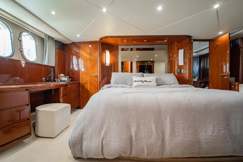 Slide: The Image of Luxurious 2004 Viking Princess Flybridge yacht bedroom with elegant wood finishes and cozy bedding. - 33