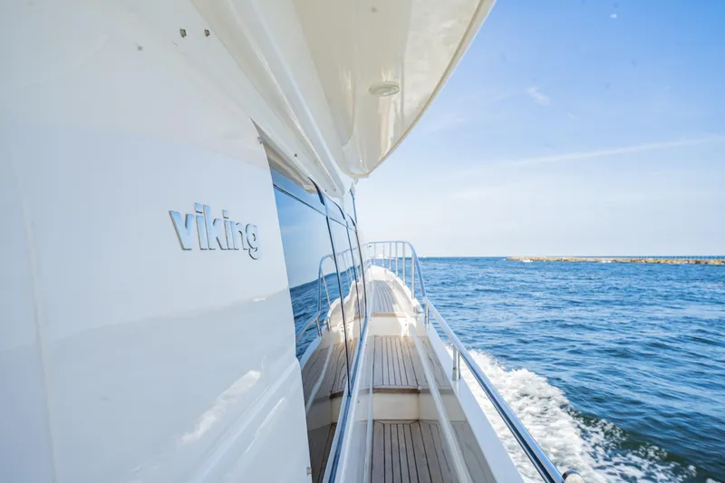 Slide: The Image of 2004 Viking Princess Flybridge yacht cruising on open sea under clear blue sky. - 4