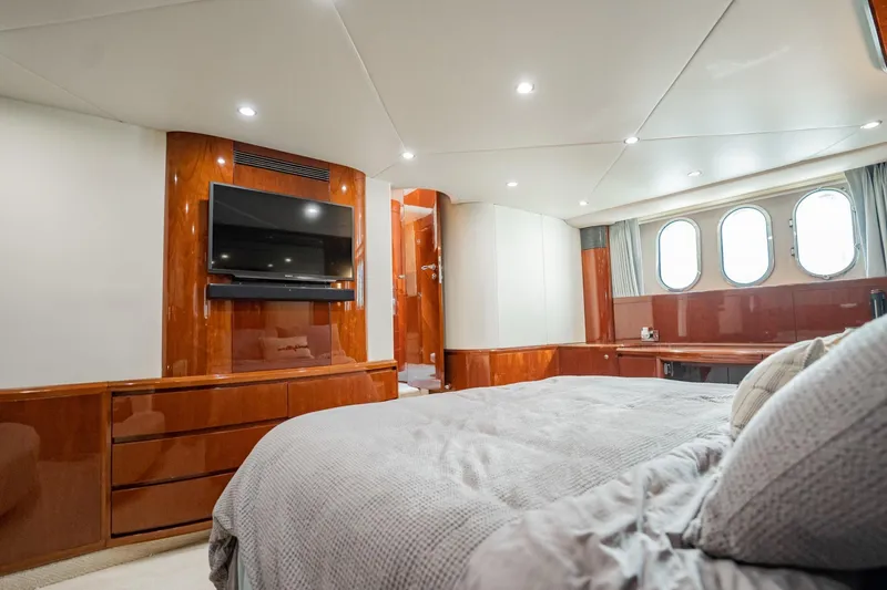Slide: The Image of Luxurious 2004 Viking Princess Flybridge yacht bedroom with wood accents and porthole windows. - 45