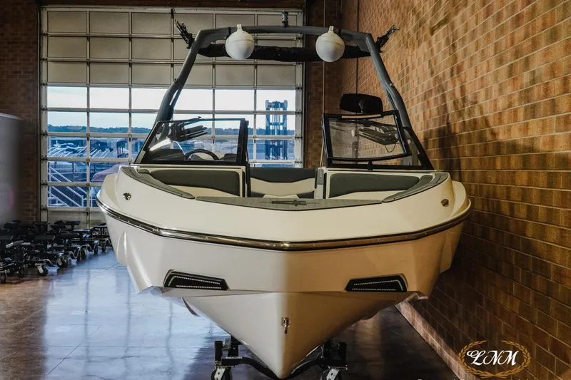 Slide: The Image of 2026 Axis T235 boat in showroom, front view, brick wall background. - 3