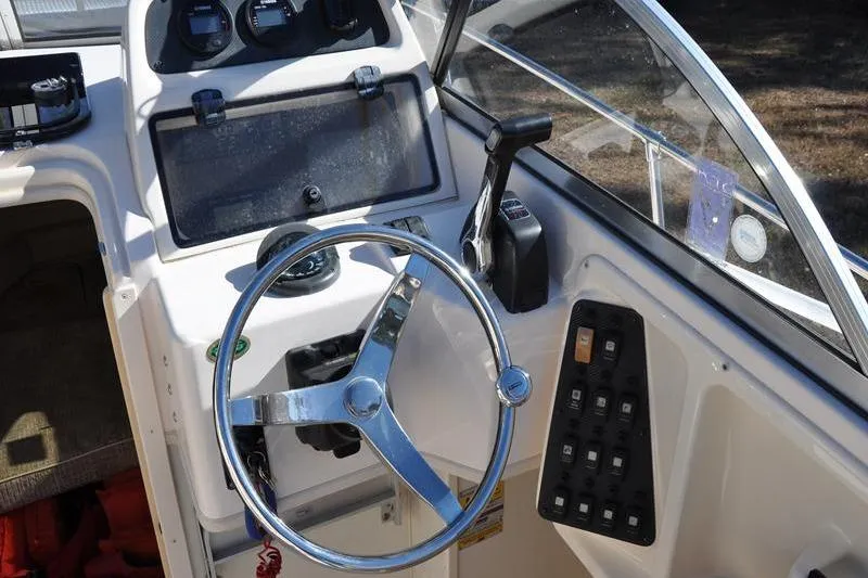 Slide: The Image of 2007 Grady-White Seafarer 226 boat cockpit with steering wheel and control panel. - 21