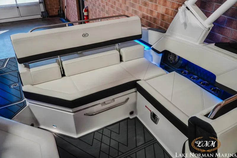 Slide: The Image of 2026 Cobalt R4 boat interior with white seating, blue LED lighting, and cup holders at Lake Norman Marina. - 18