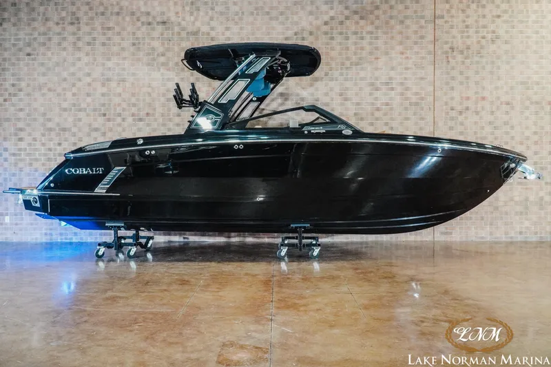 The Image of 2026 Cobalt R8 Surf boat in showroom, sleek black design, displayed at Lake Norman Marina. - 0