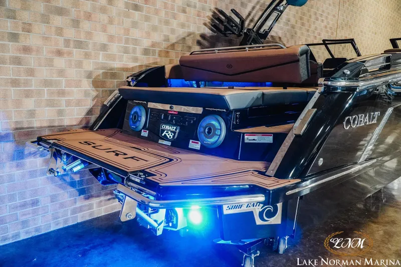 Slide: The Image of 2026 Cobalt R8 Surf boat with illuminated deck at Lake Norman Marina. - 4