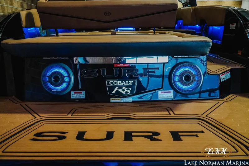 Slide: The Image of 2026 Cobalt R8 Surf boat with illuminated speakers at Lake Norman Marina. - 5