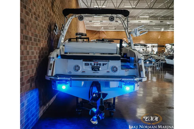 Slide: The Image of 2026 Cobalt R4 Surf boat with blue LED lights at Lake Norman Marina. - 12