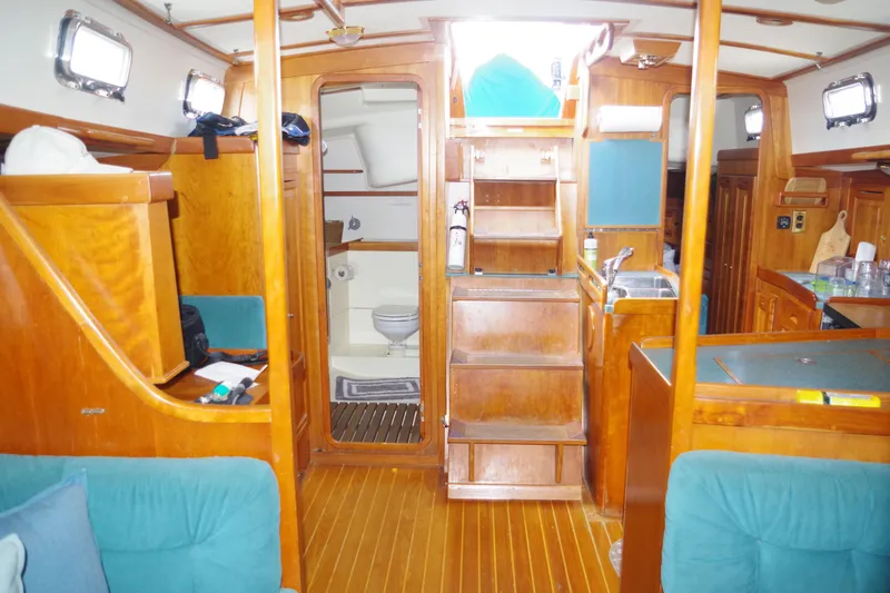 Slide: The Image of Interior of 2001 Tartan 4100 sailboat with wooden cabinetry and visible bathroom. - 11