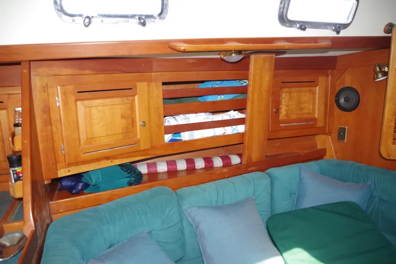 Slide: The Image of Interior of a 2001 Tartan 4100 sailboat with wooden cabinets and teal cushions. - 13