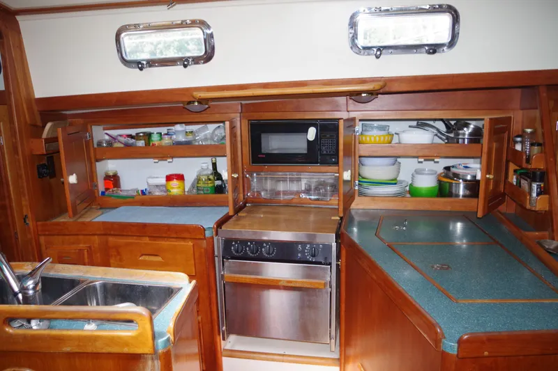 Slide: The Image of 2001 Tartan 4100 yacht kitchen with wooden cabinets and modern appliances. - 16
