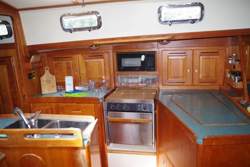 Slide: The Image of 2001 Tartan 4100 yacht kitchen with wooden cabinets and modern appliances. - 17