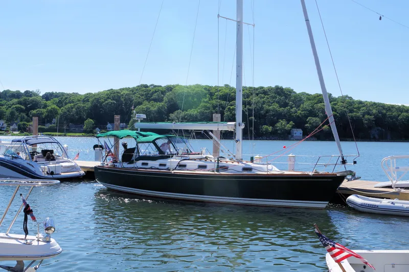 Slide: The Image of Sailboat Tartan 4100 (2001) docked in a scenic marina with lush green backdrop. - 2