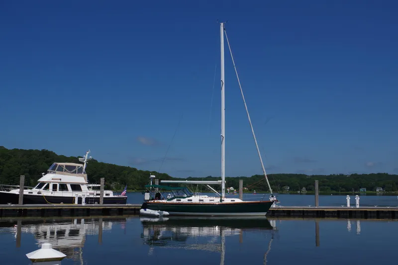 Slide: The Image of Sailboat Tartan 4100, 2001 model, docked in a serene marina under clear blue skies. - 3