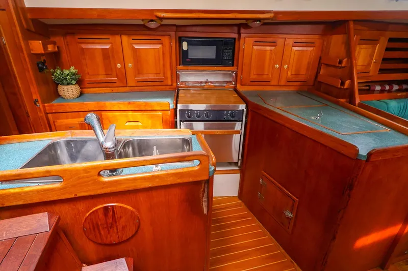 Slide: The Image of 2001 Tartan 4100 yacht kitchen with wooden cabinetry and modern appliances. - 36