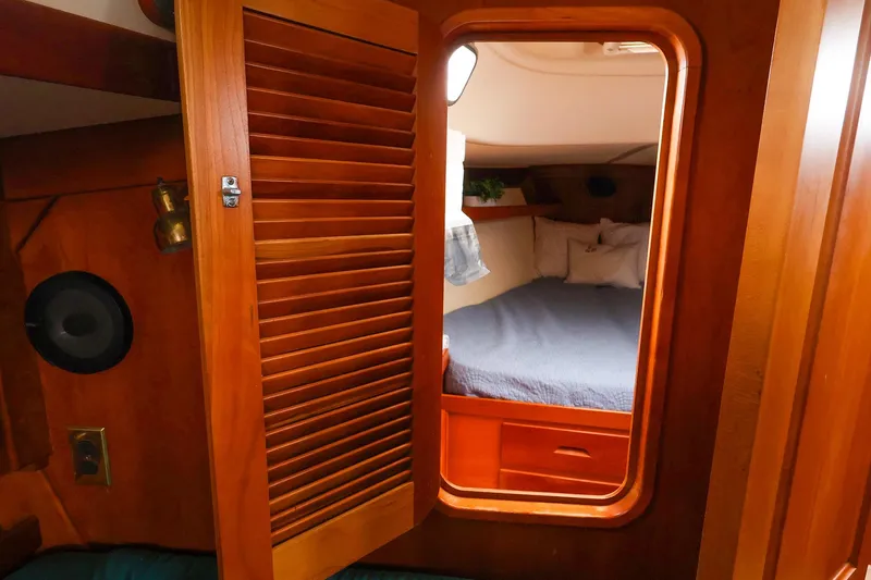 Slide: The Image of Cozy cabin interior of 2001 Tartan 4100 sailboat with wooden door and bed. - 46