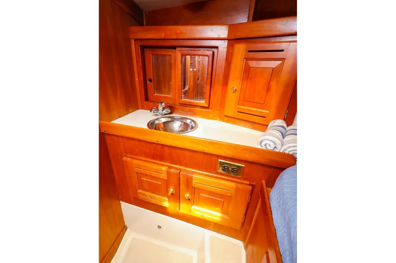 Slide: The Image of Wooden yacht bathroom with sink, mirror, and storage cabinets in a 2001 Tartan 4100. - 49