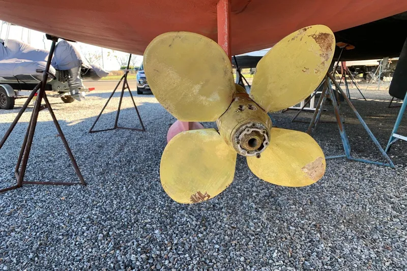 Slide: The Image of Yellow propeller of 2001 Tartan 4100 sailboat on gravel, supported by stands. - 61