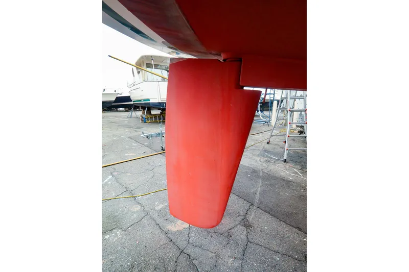 Slide: The Image of Red rudder of a 2001 Tartan 4100 sailboat in a boatyard setting. - 62