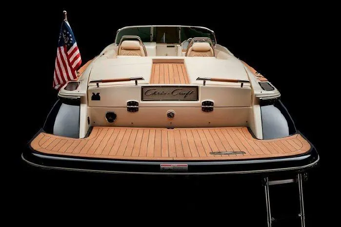 Slide: The Image of 2024 Chris-Craft Launch 27 boat, rear view with American flag, teak deck, and swim platform. - 20