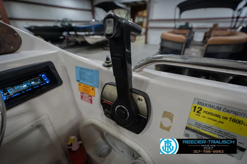 Slide: The Image of 2002 Hurricane SunDeck Sport 232 OB boat controls and capacity label in a showroom. - 39