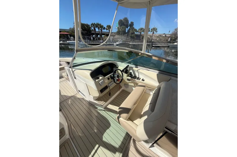 Slide: The Image of 2018 Regal 33 OBX boat helm with beige seating and waterfront view. - 11