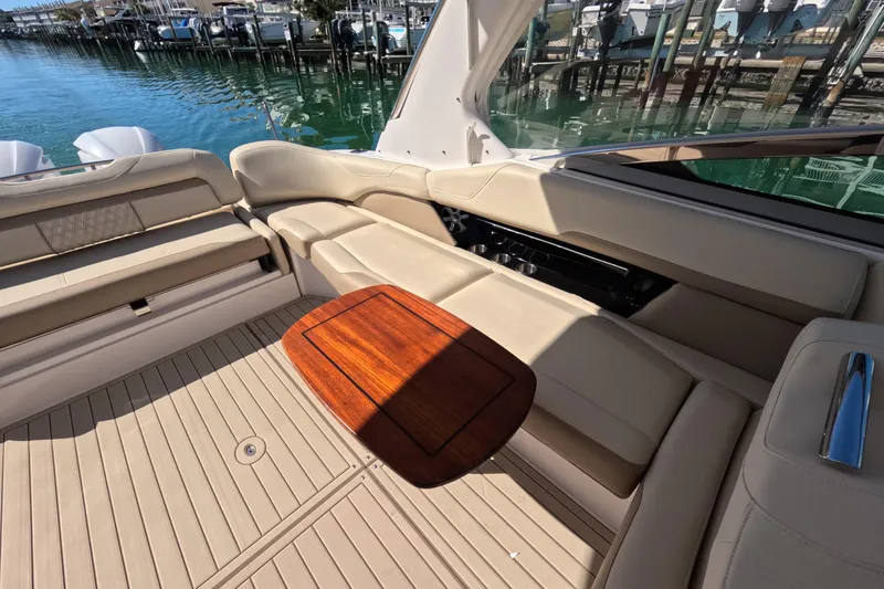Slide: The Image of 2018 Regal 33 OBX boat interior with beige seating and wooden table. - 16