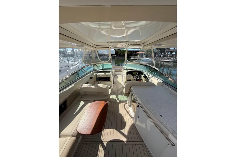 Slide: The Image of 2018 Regal 33 OBX boat interior with seating, table, and helm in a marina setting. - 19