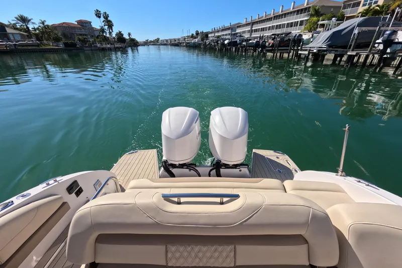 Slide: The Image of 2018 Regal 33 OBX boat cruising on a sunny canal with dual outboard engines. - 22