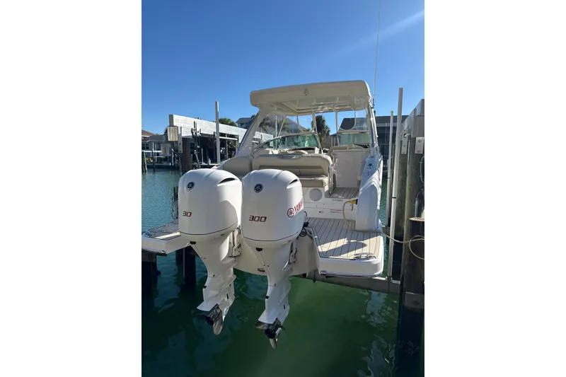 Slide: The Image of 2018 Regal 33 OBX boat with twin Yamaha 300 engines docked in sunny marina. - 5