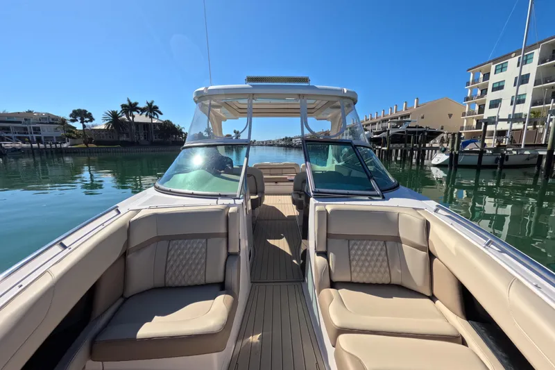 Slide: The Image of 2018 Regal 33 OBX boat with luxurious seating on a sunny waterfront. - 9