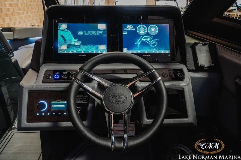 Slide: The Image of 2026 Cobalt R6 Surf boat dashboard with dual Garmin displays and sleek steering wheel. - 13