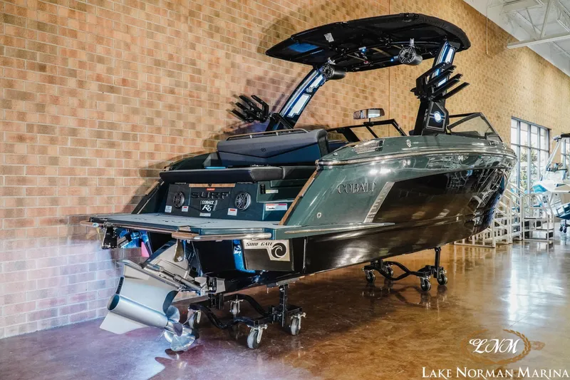 Slide: The Image of 2026 Cobalt R6 Surf boat displayed indoors at Lake Norman Marina. - 2
