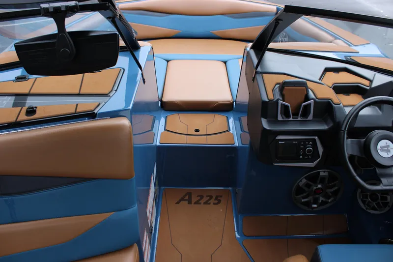 Slide: The Image of 2023 Axis A225 boat interior with blue and tan upholstery, modern dashboard, and steering wheel. - 8