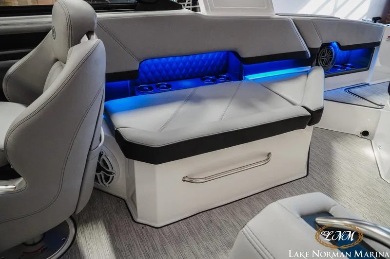 Slide: The Image of 2026 Cobalt R8 boat interior with gray seating, blue LED lighting, and cup holders. - 26