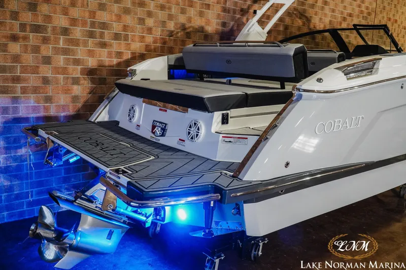 Slide: The Image of 2026 Cobalt R8 boat with illuminated deck and sleek design at Lake Norman Marina. - 7