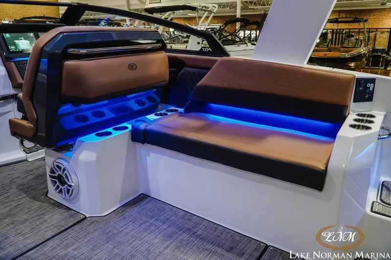 Slide: The Image of 2026 Cobalt R31 boat interior with brown seating, blue LED lighting, and cup holders at Lake Norman Marina. - 18