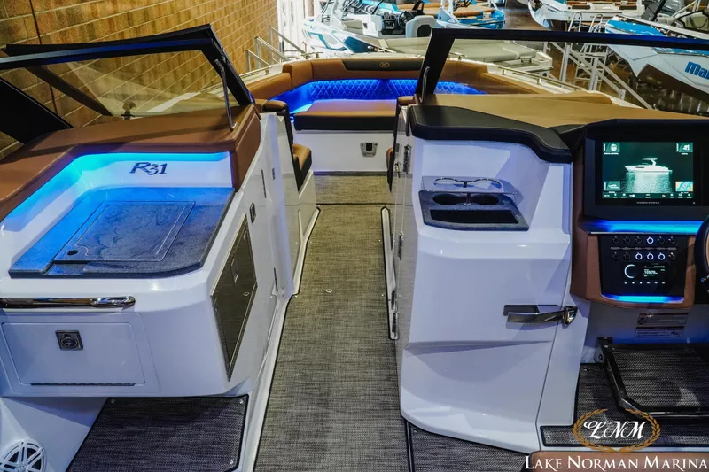 Slide: The Image of 2026 Cobalt R31 boat interior with modern dashboard, blue LED lighting, and luxurious seating. - 23