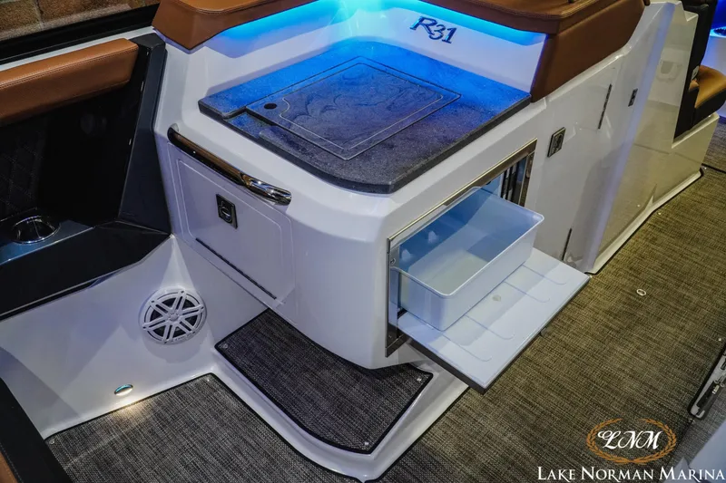 Slide: The Image of 2026 Cobalt R31 boat interior with storage compartment and blue LED lighting. - 25