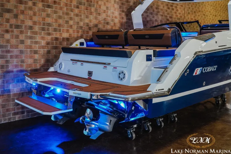 Slide: The Image of 2026 Cobalt R31 boat with illuminated deck and propellers at Lake Norman Marina. - 7
